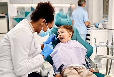 a child having their mouth examined by a pediatric dentist