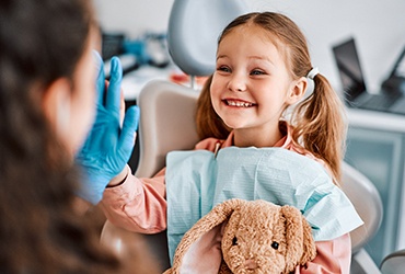 Young girl smiling while high-fiving dentist at checkup