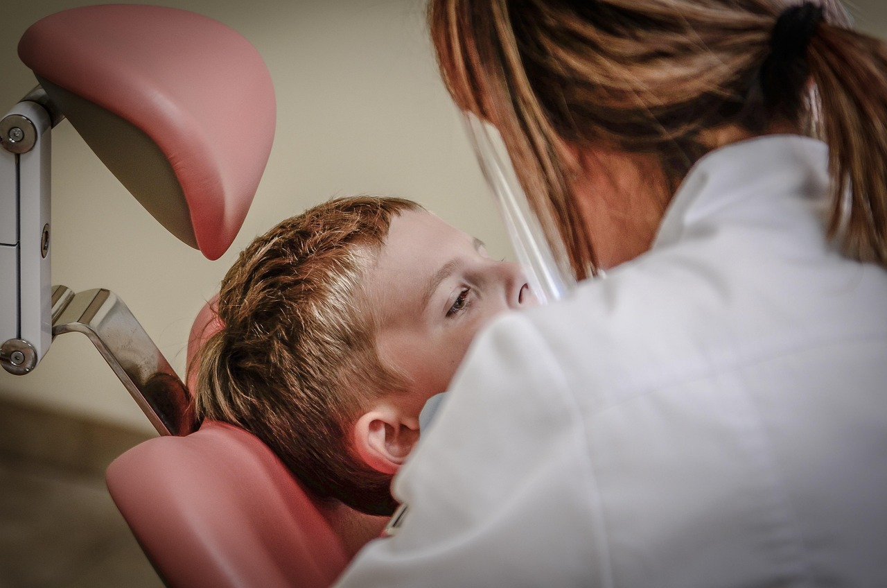 Child smiling in dental chair at Hi Five Kids Dental
